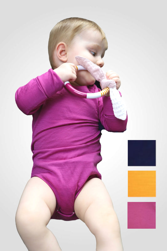 Bábätko oblečené v cyklámenovom merino body. Jemný, priedušný materiál z merino vlny chráni citlivú pokožku.
