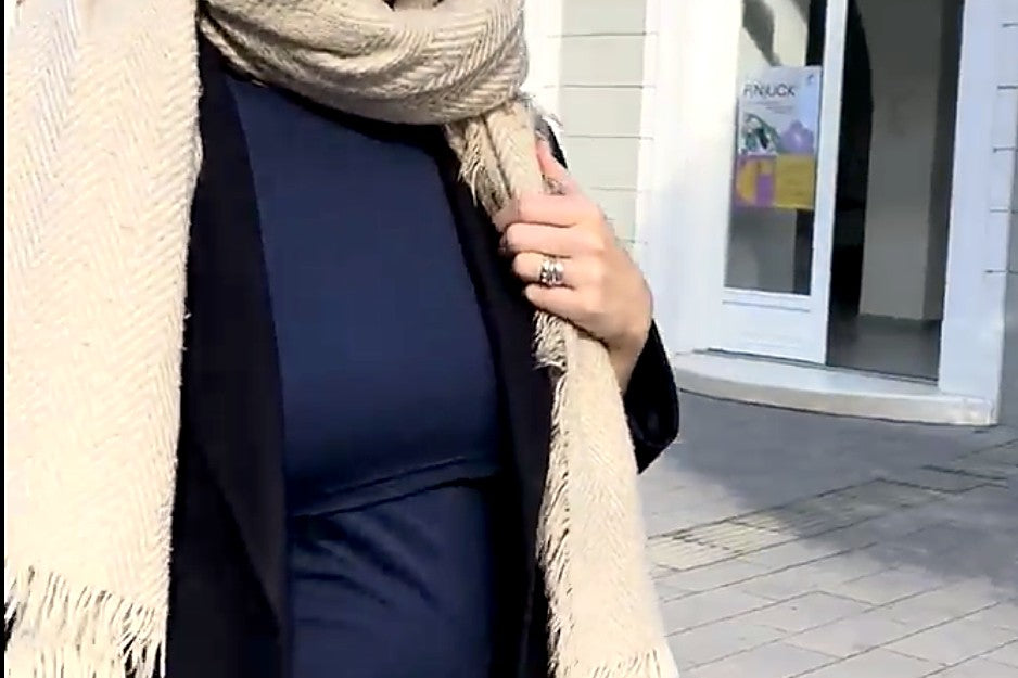 Mama v zime vonku v kabáte a šále, pod nimi tričko na dojčenie s prestrihom FOLD