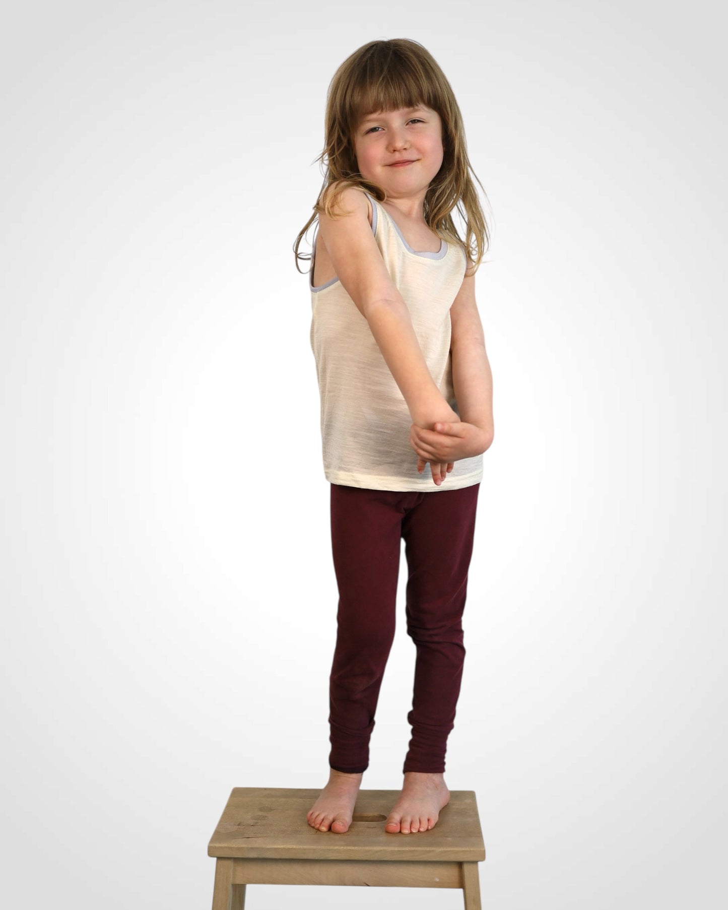 Nefarbené merino tielko pre deti, jemné k pokožke, s farebným detailom na leme.