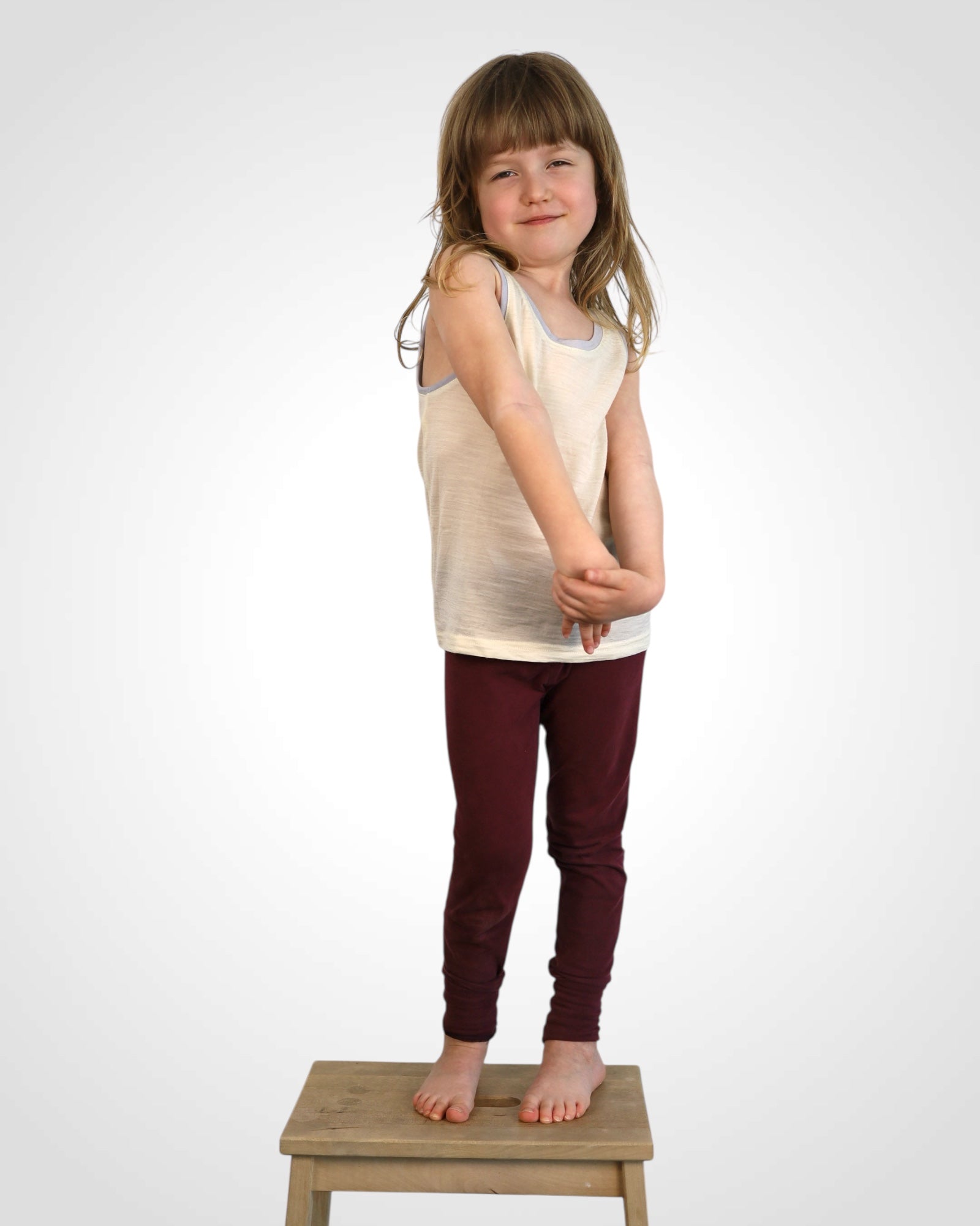 Nefarbené merino tielko pre deti, jemné k pokožke, s farebným detailom na leme.